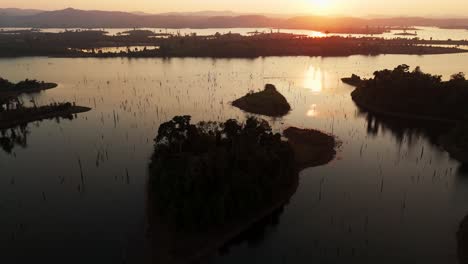 aerial fly sunset reflection above flooded islands of laos, thakhek loop, famous motorcycle ride landscape