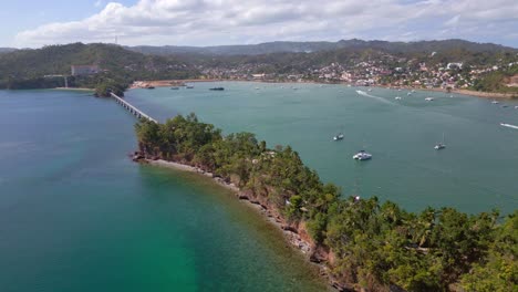 Pedestrian-bridge-leads-to-famous-island-Cayo-Vigia-in-Samana,-aerial-orbit