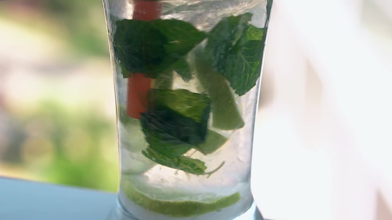 민트 잎 을 가진  ⁇ 색 표면 에 있는 모지토 스탠드 가 있는 유리