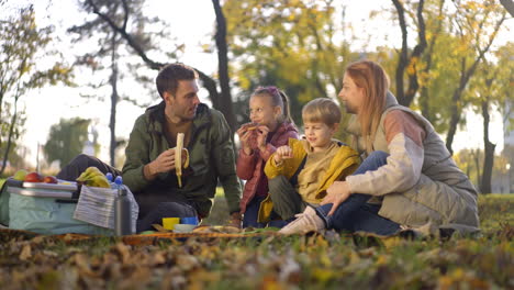 family enjoying a picnic in the park during autumn