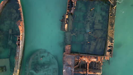 drones en primer plano barco oxidado naufragio abandonado en el océano azul, vehículo oxidado