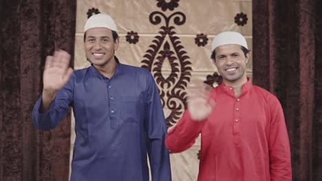 two muslim men waving hand and greeting hello