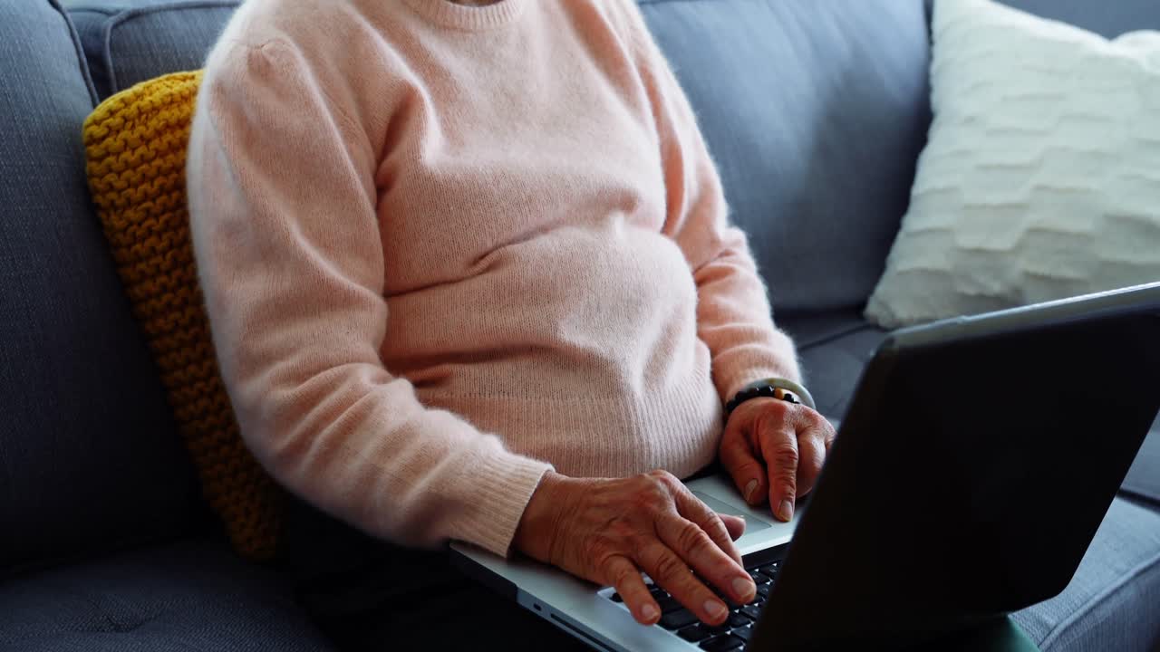 Senior woman using laptop in living room