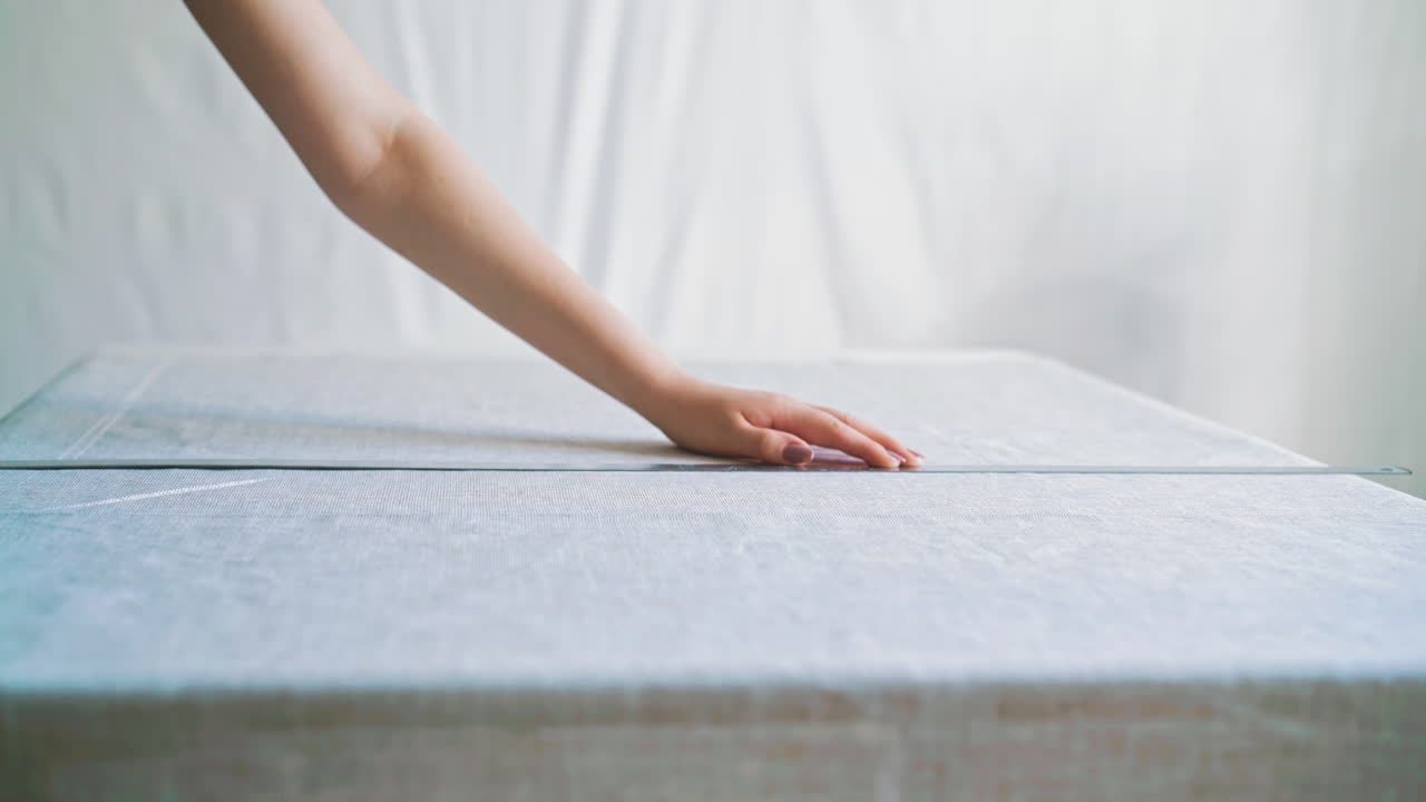 여자 는 재질 시트 에 크레이드 와 금속 통치기 를 사용 하여 표시 를 한다