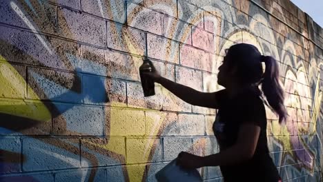 an artist uses spray paint to create a colorful mural on a concrete wall. the artwork comes to life with bold shapes and vivid colors as the sun sets, enhancing the creative process and atmosphere.