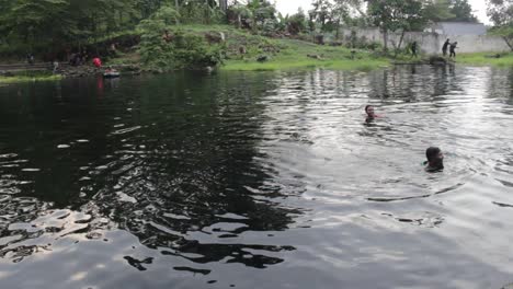 umbulan baths, pasuruan-indonesia. january 2020. young people are playing in a clear and fresh water source. holiday footage playing nature water