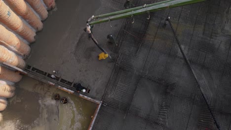 Aerial-view-of-construction-workers-pouring-concrete-on-building-construction-site-later-revealing-neighborhood,-Tel-Aviv,-Israel