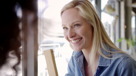 two female friends meeting in coffee shop shot in slow motion
