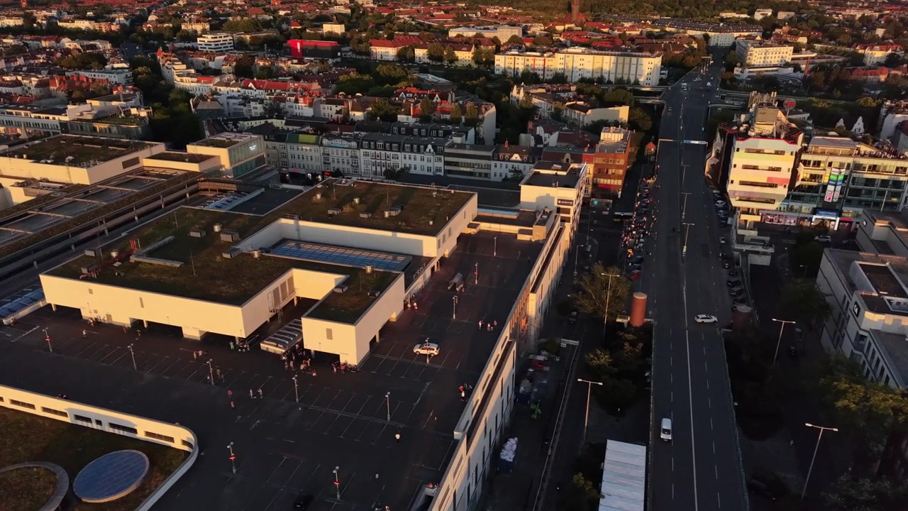 Persone si radunano su un ampio tetto urbano, guardando il cielo durante un'eclissi solare a Berlino. Splendida vista aerea, sorvolo panoramico con drone