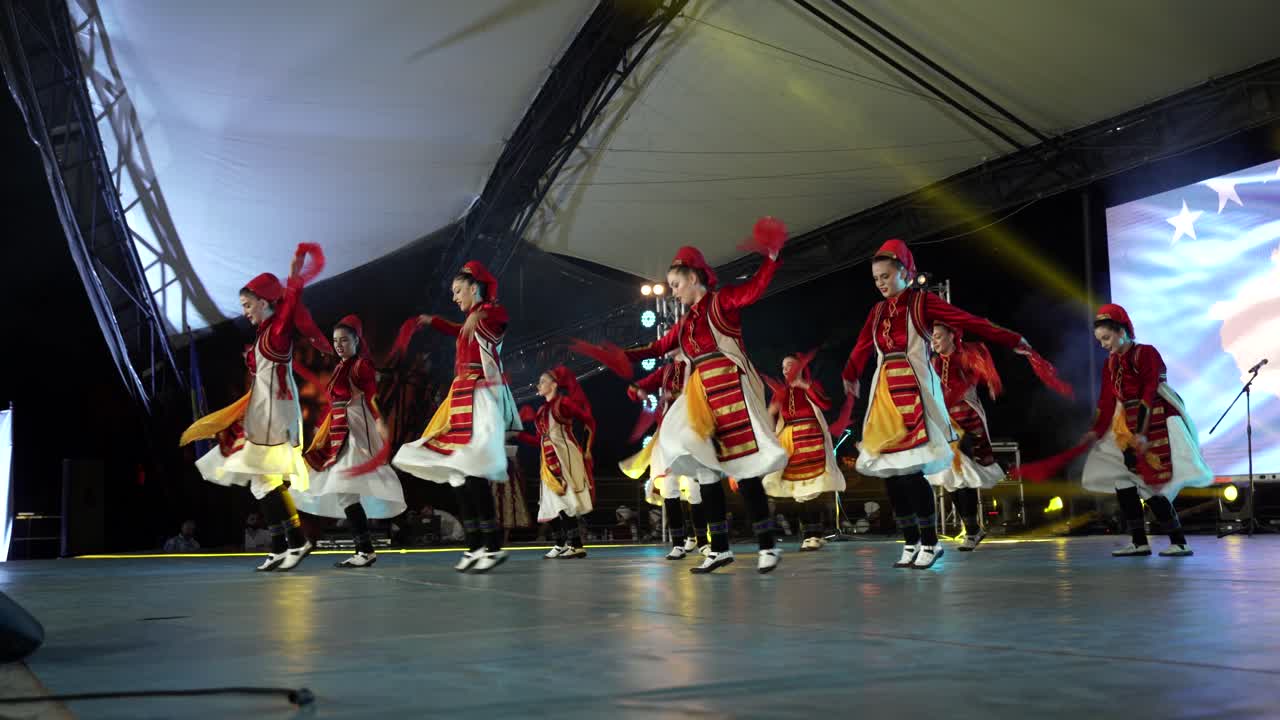 Women dressed in beautiful traditional clothes dancing Albania folk music in stage