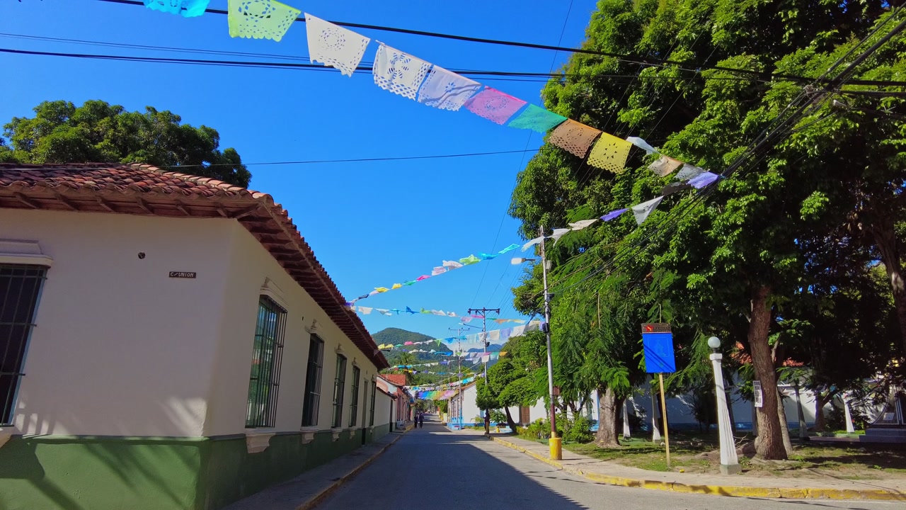 POV shot of a walk through the streets of the beach town of Choroni, featuring colorful colonial houses adorned with colorful pennants, Venezuela