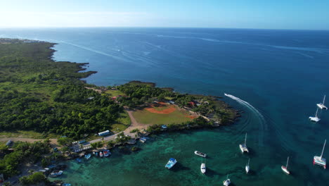 epic aerial view of a baseball playground in the dominican republic in the coast with a small boat in the sea