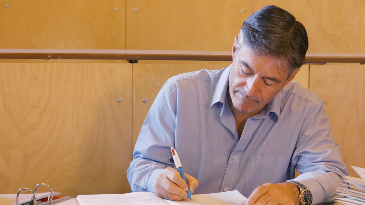 el profesor guapo calificando algunos papeles.