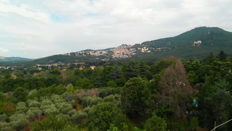 AERIAL:-Drone-rises-revealing-Rocca-di-Papa's-town-in-the-Roman-province,-Italy-with-a-stunning-view-of-the-small-remote-village-on-top-the-hills