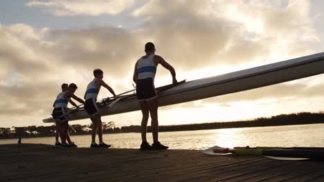 male rower team taking out of the lake the boat