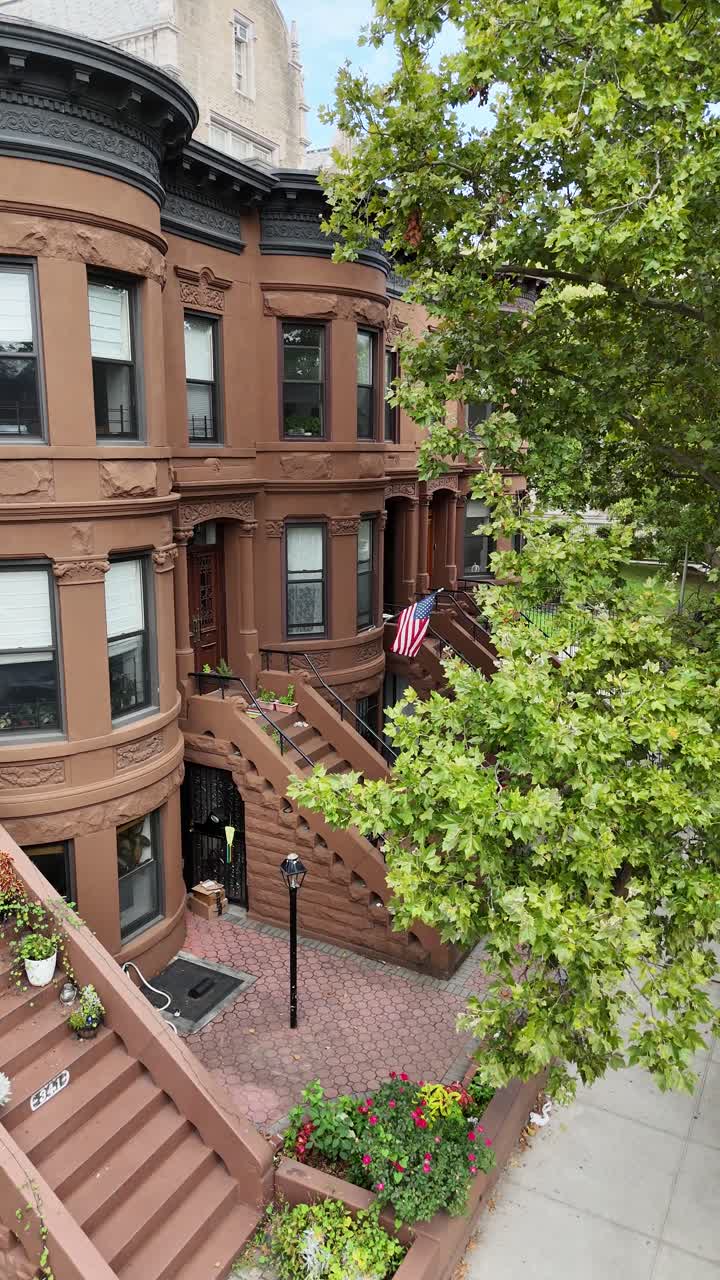 A low-angle drone side-tracking shot along Senator Street in Brooklyn, showcasing detailed views of buildings and residential architecture during the daytime.