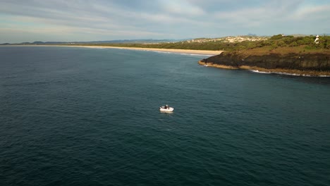 Boat-near-Fingal-Head-at-sunrise,-Northern-New-South-Wales,-Australia