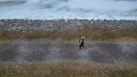 aerial drone following a young woman on a winter day