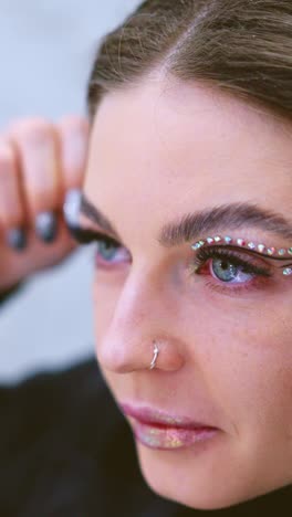 woman with rhinestone eye makeup and glitter lips