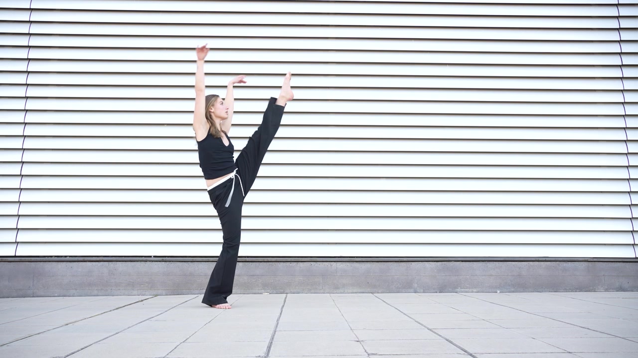 Movimenti di danza dinamici ed espressivi eseguiti su uno sfondo a strisce visivamente suggestivo.
