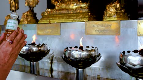 pouring oil into temple lamps for merit