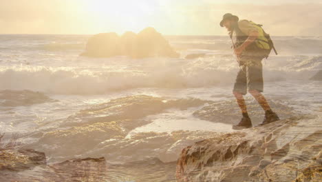 male hiker navigating rocky coastal shoreline at sunset, with animated travel route overlay