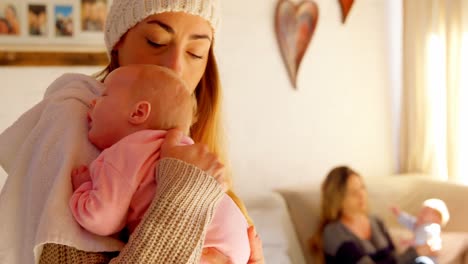 madre consolando a su bebé en la sala de estar 4k