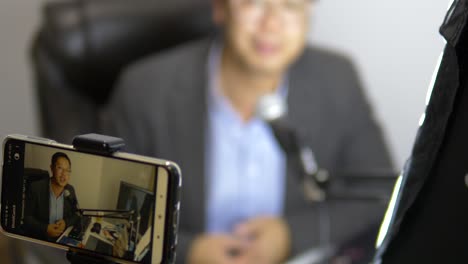 man-livestreams-onto-phone-with-background-blurred-out-of-focus