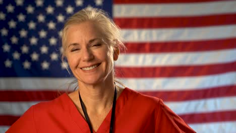 medium tight portrait of a smiling and happy healthcare nurse with out of focus american flag