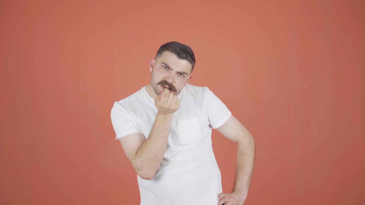 The man is biting his nails.