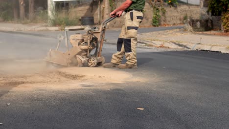 closeup cortando asfalto con una máquina de hoja de sierra de diamante en el sitio de construcción de carreteras