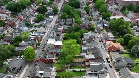 two straight streets with row of houses in city of united states. aerial flyover. green trees in spring. historic colored townhouses in lancaster, pennsylvania.