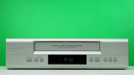vintage vhs player with hand inserting tape