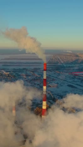 aerial view of industrial plant with smoke stack on a snowy day