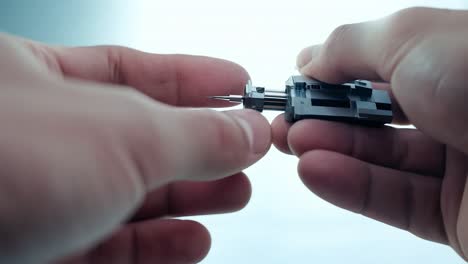 close-up of a person holding a small metal part