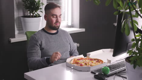 hungry man having a break and eating tasty pizza at office 1