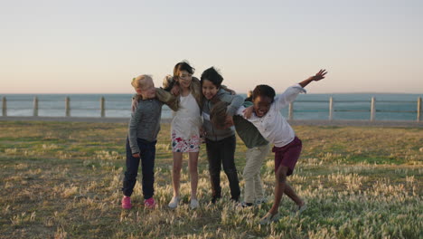 happy cheerful kids portrait of excited children group embracing celebrating enjoying seaside beach fun at sunset