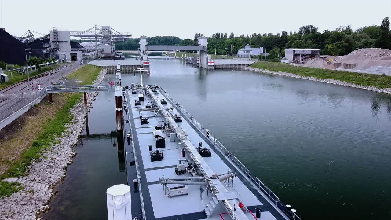 Drone flight over a cargo ship in an european canal with overcast skies