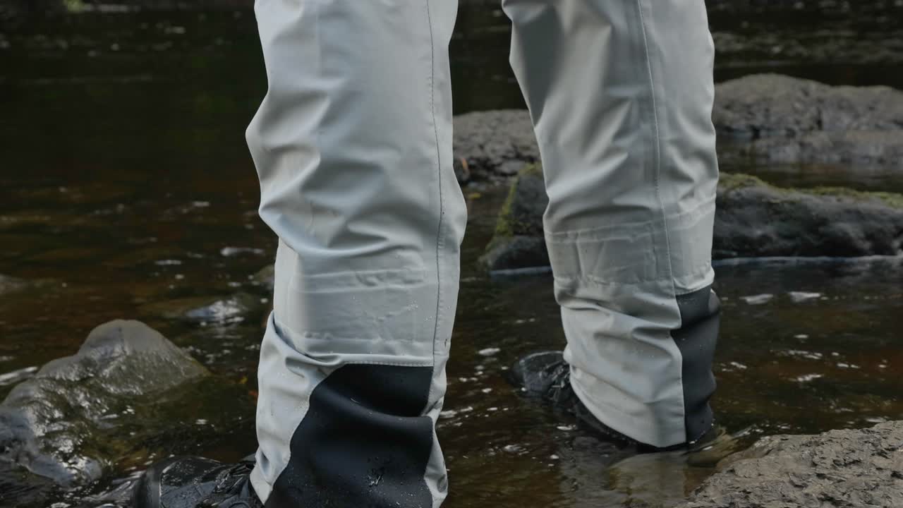 disparo de bajo ángulo de un pescador de pie en barcazas llenas con agua fluyendo por delante
