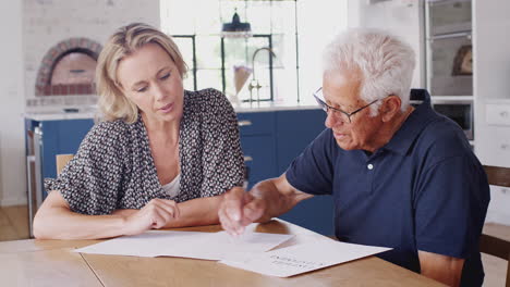 woman helping senior man to complete last will and testament at home