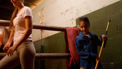 mother and daughter cleaning stable 4k