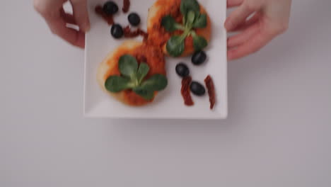 small pizzas with olives and sun-dried tomatoes