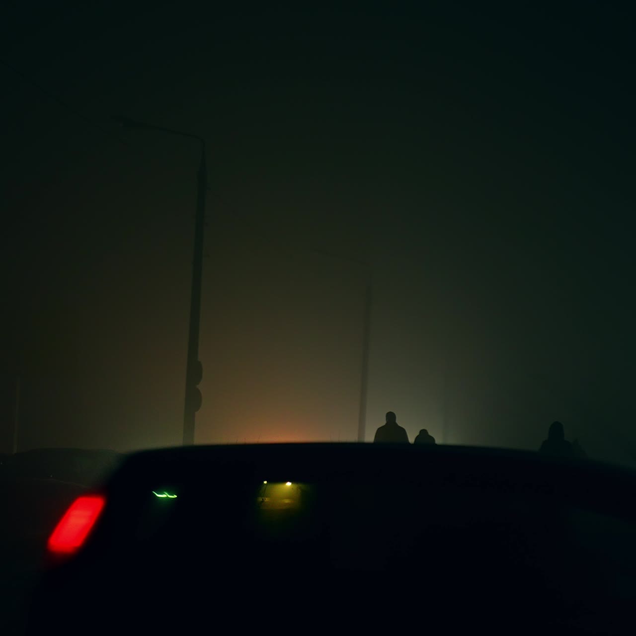 Transport and sidewalk in the dark city at the time of blackout. People walk in the light of car spotlights at night