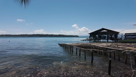 rustic dock over calm waters on bastimentos island, panama, under a bright blue sky