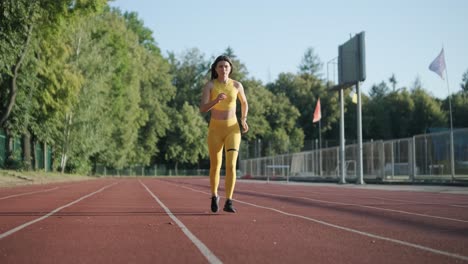 woman running on outdoor track in yellow sportswear