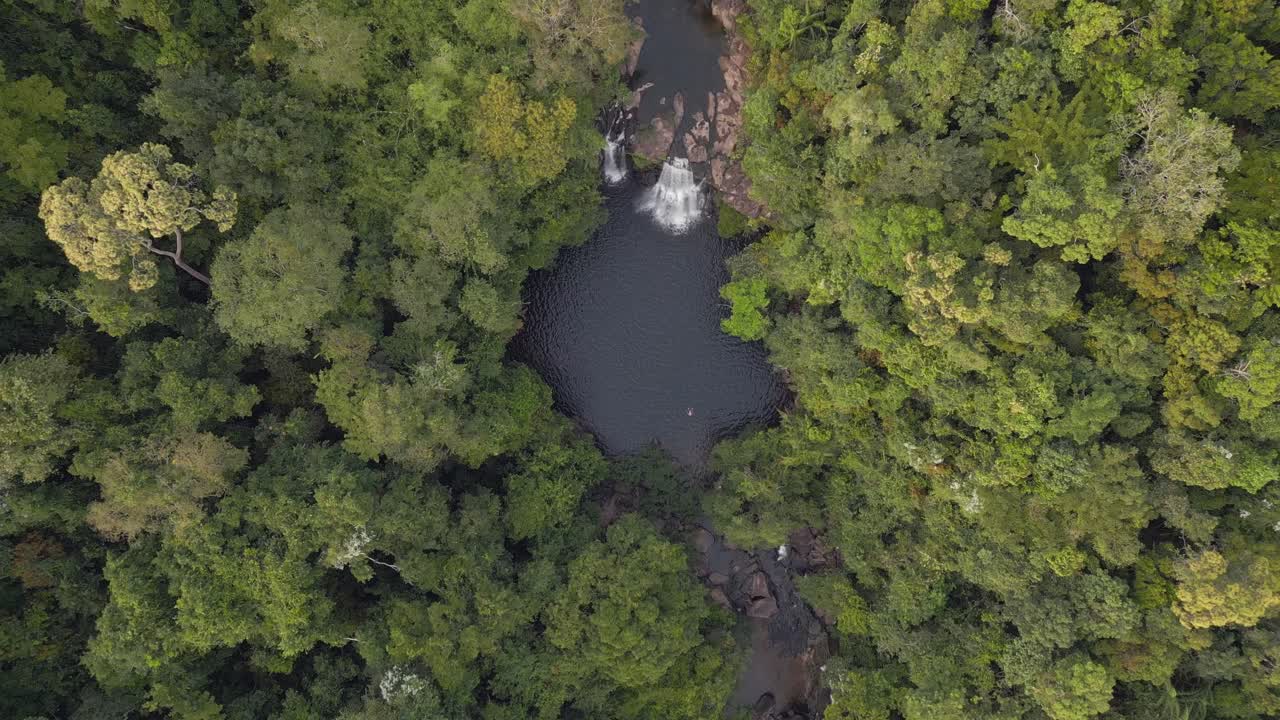 persona nada sola en el lago desde la cascada