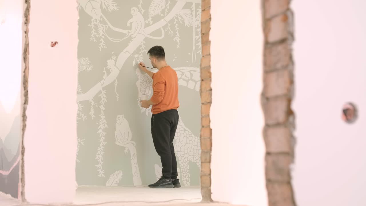 L'artista decora le pareti con disegni nella cameretta dei bambini. Pittura artistica delle pareti nella nuova casa. Lavori di ristrutturazione
