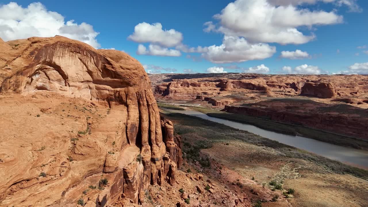 Aerial view of Rugged Red Cliffs with River at Bottom of Canyon, Blue Sky with Patches of Clouds, Colorado River, Highway 128 in Moab Utah, early spring