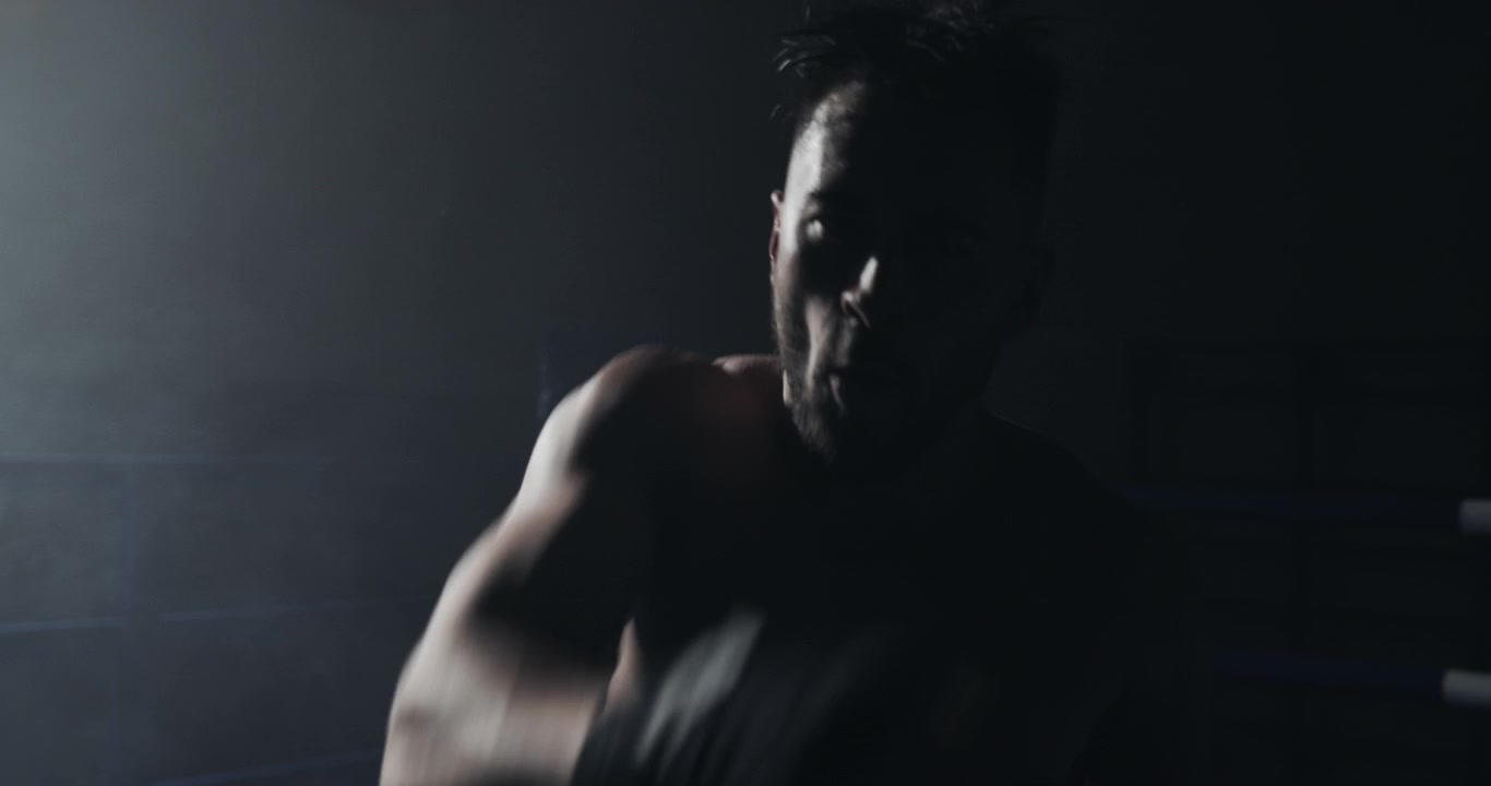 Shirtless Boxer Shadow Boxing in a Dark, Smoky Ring