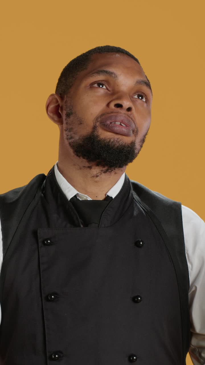 Chef afroamericano che guarda in su pensieroso in studio